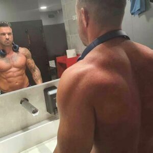 Homme tatoué musclé devant miroir